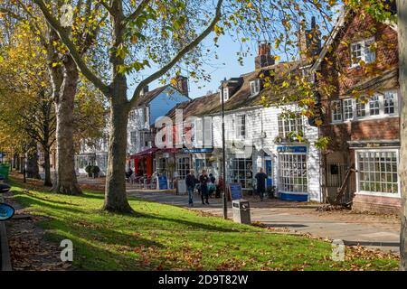 Das breite Bürgersteig der Tenterden High Street mit Geschäften und Cafés mit Menschen essen in Autumn Sunshine, Kent, UK, GB Stockfoto