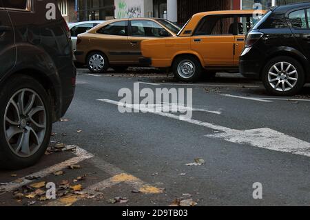 Altes Auto zwischen neuen Autos auf der Straße geparkt Stockfoto