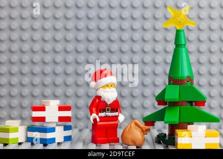 Tambow, Russische Föderation - 4. November 2020 Lego minifigur Weihnachtsmann steht in der Nähe eines Weihnachtsbaumes mit Geschenken darunter. Stockfoto