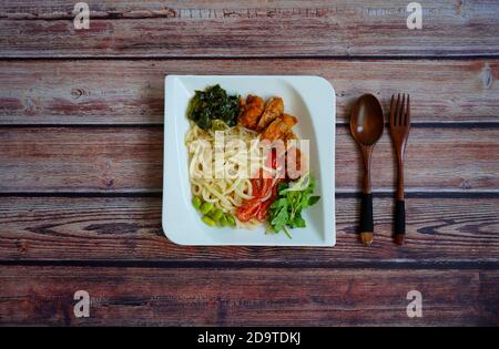 Japanischer Salat mit udon-Nudeln, Huhn, Spinat, Edamame (Soja) Bohnen und Gemüse. Stockfoto