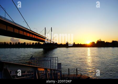 Theodor-Heuss-Brücke, eine Seilbrücke, die den Rhein überquert. Foto vom Flussufer im Landkreis Golzheim. Stockfoto