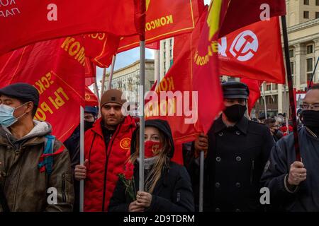 Moskau, Russland. 7. November 2020 Anhänger der kommunistischen Partei, die Gesichtsmaske mit roten Fahnen tragen, versammeln sich, um Blumen im Wladimir-Lenin-Mausoleum zu legen, um den 103. Jahrestag der bolschewistischen Revolution vom 1917. Oktober auf dem Roten Platz in Moskau, Russland, zu begehen Stockfoto