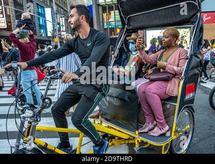 New York, USA. November 2020. Touristen werden auf dem Times Square in New York City gefeiert, nachdem die Nachricht ausbrach, dass der ehemalige Vizepräsident Joe Biden die US-Präsidentschaftswahlen gewonnen hat. Biden besiegte Präsident Donald Trump, um zum 46. Präsidenten der Vereinigten Staaten zu werden, und Kamala Harris wird die erste weibliche Vizepräsidentin sein. Kredit: Enrique Shore/Alamy Live Nachrichten Stockfoto