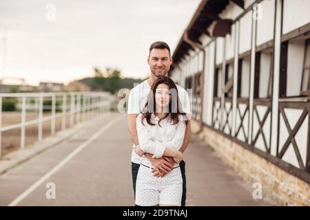 Glückliche junge Mann und Frau mit Spaß im Freien an einem warmen Sommertag. Paar umarmt in der Nähe Pferd rancho Stockfoto