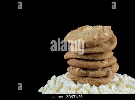 Stapel von hausgemachten Macadamia-Nuss-Cookies auf weißen Schokoladenstückchen Stockfoto