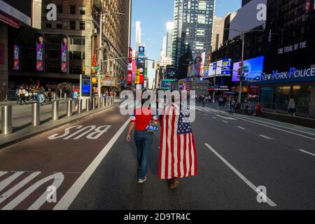 New York, USA, 7.. November 2020. Ein Paar geht zum Times Square, um an der Feier des Gewinns von Joe Biden bei den US-Präsidentschaftswahlen in New York City am Samstag, den 7. November 2020, teilzunehmen. Kredit: Shoun A. Hill/Alamy Live Nachrichten. Stockfoto