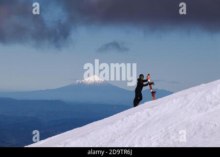 Blick auf den Mount Taranaki vom Turoa Skifield, Snowboarder im Hintergrund, Wintersaison, Neuseeland Stockfoto