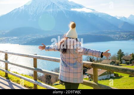 Ein Reisefoto einer schönen asiatischen Frau, die während ihres vac glücklich die natürliche Landschaft des Flusses und des Sees neben dem Berg betrachtet Stockfoto