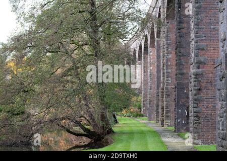 Kilver Court Gardens, historischer Garten am See unter dem stillvollen viktorianischen Charlton Viadukt, fotografiert im Herbst mit sich verfärbendem Laub. Stockfoto