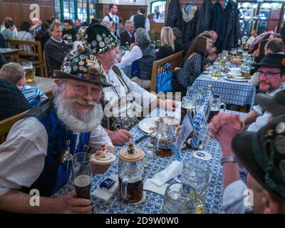 In der Hofbrahaus-Bar in München treffen sich bayerische Männer zu Touristen. Stockfoto