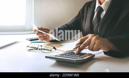 Finanzarbeiter berechnen die Unternehmensgewinne aus Diagrammen auf ihren Schreibtischen zu Hause, Finanzideen und Auditing. Stockfoto