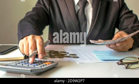 Finanzarbeiter berechnen die Unternehmensgewinne aus Diagrammen auf ihren Schreibtischen zu Hause, Finanzideen und Auditing. Stockfoto