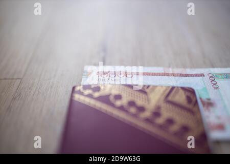 Zehntausend kolumbianische Pesos Bill teilweise in einem schwedischen Pass Stockfoto