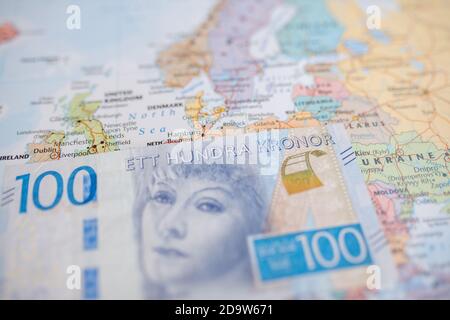 Hundert schwedische Kronen Bill auf der Oberseite eines verschwommen Und bunte europäische Karte Stockfoto