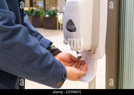 Person Reinigung der Hand mit antibakteriellen Diinfektant Desinfektionsmittel im öffentlichen Einkaufszentrum Stockfoto