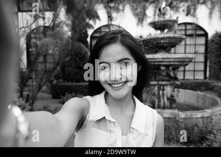 Junge schöne asiatische Frau, die Selfie beim Lächeln Stockfoto