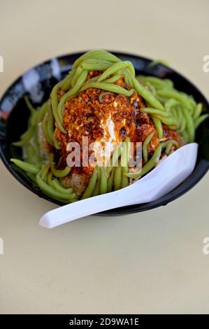 Eine Schüssel Chendol, ein eissüßes Dessert mit Gelee aus grünem Reismehl, Kokosmilch und Palmzucker-Sirup, das häufig in Südostasien zu finden ist. Stockfoto