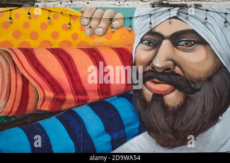 Ein Wandgemälde in der Ong Ang Walking Street von Klong Ong Ang, Chinatown / Phahurat, Bangkok, Thailand, zeigt einen Sikh Textilhändler Stockfoto