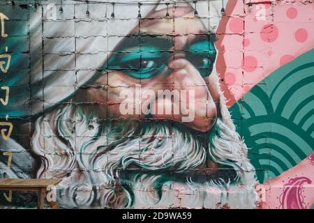 Ein Wandgemälde in der Ong Ang Walking Street von Klong Ong Ang, Chinatown / Phahurat, Bangkok, Thailand, zeigt einen Sikh Textilhändler Stockfoto