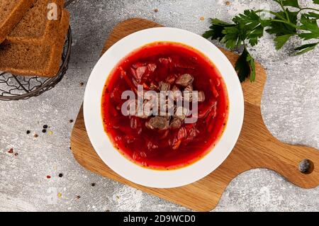 Russische Suppe borscht mit Rote Bete auf einem weißen Teller Ein Holzbrett Stockfoto