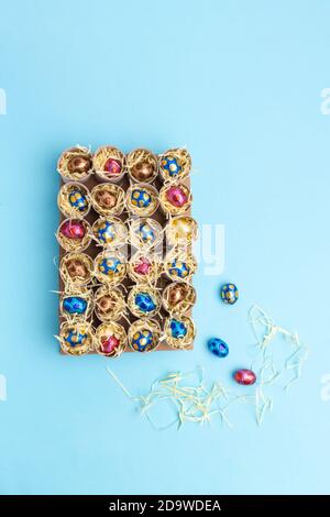 Toilettenrolle Adventskalender Handwerk, DIY, Schritt 3, Füllen mit Süßigkeiten, Draufsicht, blauer Hintergrund, Aktivität für Kinder Tutorial Stockfoto