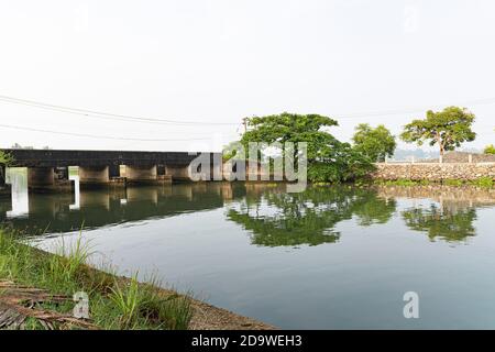 Kerala Flussbrücke Fotografie mit Baum auf der anderen Seite von Kadamakkudy, Ernakulam, Kochi, Kerala, Indien.auf weiß verschwommen Umgebung Stockfoto