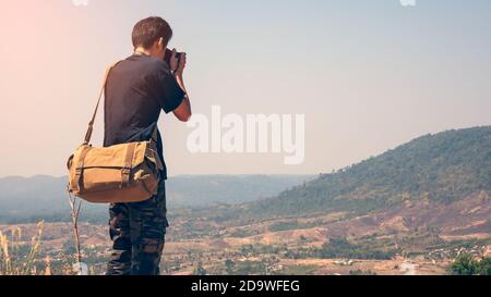 Nahaufnahme Rückansicht eines Fotografen, der auf einem Berg fotografiert. Stockfoto