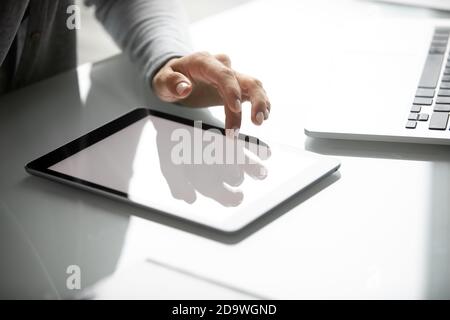Junge Frau hält Hand über digitale Tablette mit weißem Bildschirm Stockfoto