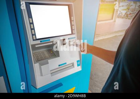 Ein Mann benutzt eine ATM-Karte Stockfoto
