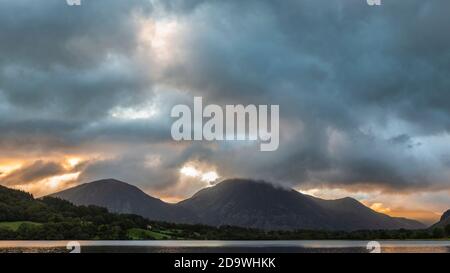 Atemberaubendes Landschaftsbild bei Sonnenaufgang mit Blick über Loweswater im See Bezirk in Richtung Low Fell und Grasmere mit bunten Himmel brechen Auf dem Berg Stockfoto