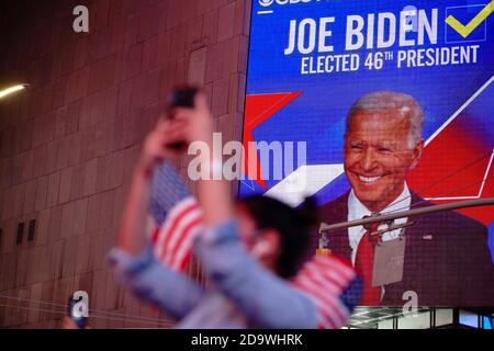 New York, Usa. November 2020. Die Menschen beobachten den Bildschirm der ABC Good Morning America GMA Studios, während der designierte Präsident Joe Biden am 7. November 2020 seine Dankesrede von Delaware auf dem Times Square in New York hält. - der Demokrat Joe Biden hat das Weiße Haus gewonnen, sagten US-Medien am 7. November, als er Donald Trump besiegte und eine Präsidentschaft beendete, die die amerikanische Politik erschütterte, die Welt schockierte und die Vereinigten Staaten mehr gespalten ließ als zu jeder Zeit seit Jahrzehnten. Kredit: SOPA Images Limited/Alamy Live Nachrichten Stockfoto