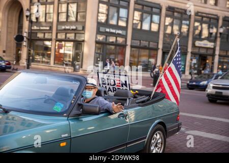 Indianapolis, Usa. November 2020. Ein Mann mit Gesichtsmaske in einem Auto feiern am Monument Circle in der Innenstadt von Indianapolis, nachdem der ehemalige Vizepräsident Joe Biden zum Sieger der Präsidentschaftswahl 2020 erklärt wurde, nachdem er den amtierenden US-Präsidenten Donald Trump besiegt hatte, um zum 46. Präsidenten der Vereinigten Staaten zu werden. Kredit: SOPA Images Limited/Alamy Live Nachrichten Stockfoto