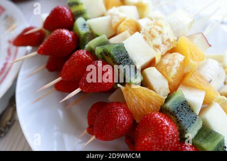Teller mit Früchten und Beeren auf Holzstäbchen Stockfoto
