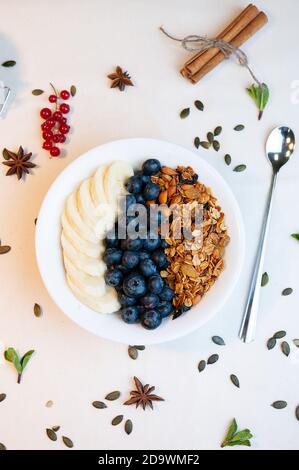 Müsli mit Beeren und Banane und Joghurt in einem Glasbecher Stockfoto