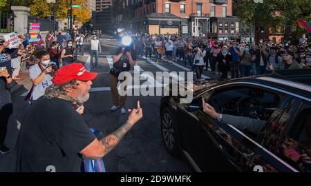 Reaktion auf das Ende der US-Präsidentschaftswahl 2020 in Boston, MA, USA. November 2020, 07. Hunderte von Joseph Biden-Anhängern sahen sich nach der Ankündigung der US-Medien, Biden habe die Wahl 2020 gewonnen, mit weniger als 50 Donald Trump-Unterstützern im Massachusetts State House in Boston konfrontiert. Rechts zeigt Biden-Anhänger, links Trump-Anhänger. In der Mitte ist ein Trump-Anhänger (L) zu einem Biden-Anhänger auf der Straße vor dem Staatshaus gestikuliert. Kredit: Chuck Nacke / Alamy Live Nachrichten Stockfoto