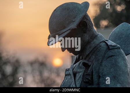 Southend on Sea, Essex, Großbritannien. November 2020. Die Sonne geht am Sonntagmorgen der Erinnerung auf, hinter dem Southend Cenotaph und dem Kriegsdenkmal. Eine bronzene „Tommy“-Figur ist eine jüngste Ergänzung, die auf Ruheleuchten steht. Am Morgen Stockfoto