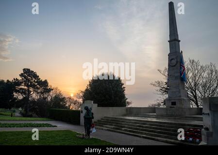 Southend on Sea, Essex, Großbritannien. November 2020. Die Sonne geht am Remembrance Sunday auf, hinter dem Southend Cenotaph und dem Kriegsdenkmal mit Blick auf die Themse-Mündung. Eine bronzene 'Tommy' Figur ist eine neue Ergänzung. Gärten Stockfoto