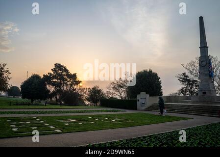 Southend on Sea, Essex, Großbritannien. November 2020. Die Sonne geht am Remembrance Sunday auf, hinter dem Southend Cenotaph und dem Kriegsdenkmal mit Blick auf die Themse-Mündung. Eine bronzene 'Tommy' Figur ist eine neue Ergänzung. Gärten Stockfoto