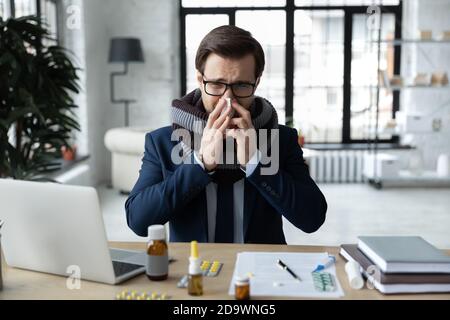 Kranke junge unglückliche Geschäftsmann leiden an ersten grippe fieberhaften Symptome. Stockfoto