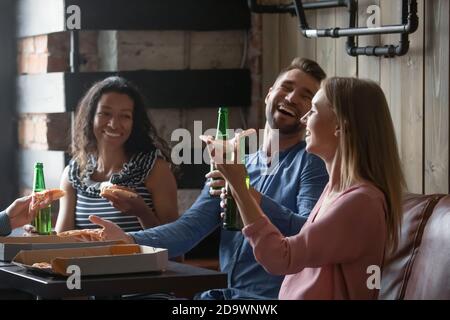 Fröhliche und vielfältige Freunde verbringen ein gemeinsames Wochenende bei Bier und Pizza Stockfoto