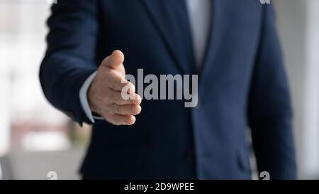 Junger Geschäftsmann, der die Hand ausstreut, um zu zittern. Stockfoto