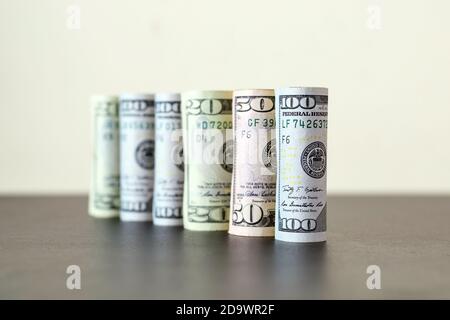 Gruppe von Dollar rollt in einem Kreis auf dem Tisch, Konzepte für Wirtschaft und Finanzen. Stockfoto