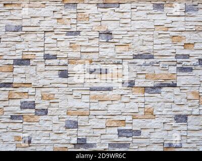 Frontansicht einer Mauer mit dekorativem Mauerwerk. Hintergrundstruktur. Vollbild Stockfoto