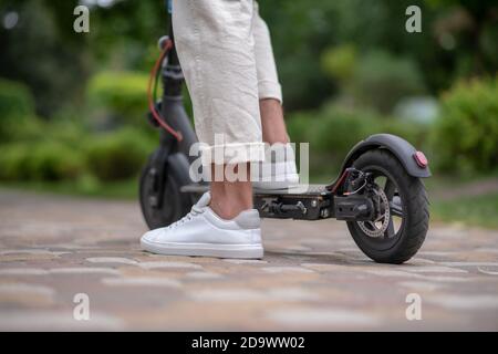 Roller. Nahaufnahme eines menschlichen Fußes, der auf einem Roller steht Stockfoto