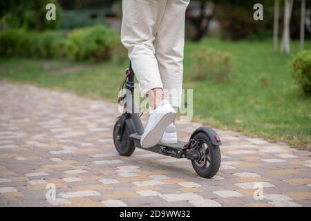 Reiten. Nahaufnahme einer Person, die einen Roller im Park fährt Stockfoto