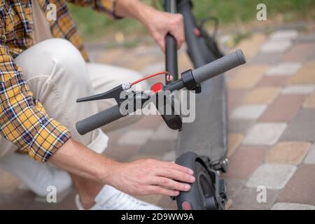 Roller. Nahaufnahme eines Mannes, der seinen Roller repariert Stockfoto
