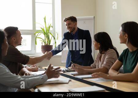 Dankbarer Teamleiter, der dem Coach die Hand schüttelt und für die Schulung des Personals dankbar ist Stockfoto