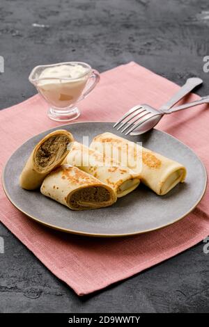 Teller mit dünnen Pfannkuchen gefüllt mit Hase Hackfleisch Stockfoto