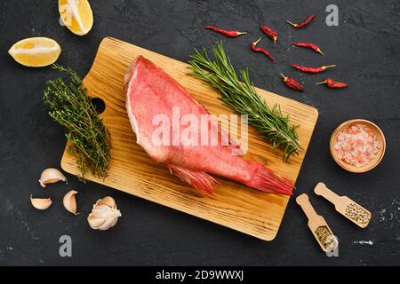 Blick von oben auf frisch gefrorenen kopflosen Ozean Barsch mit Gewürzen Und Kräuter Stockfoto