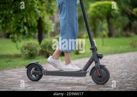 Auf einem Roller. Nahaufnahme Bild der Frau Beine auf einem Roller stehen Stockfoto